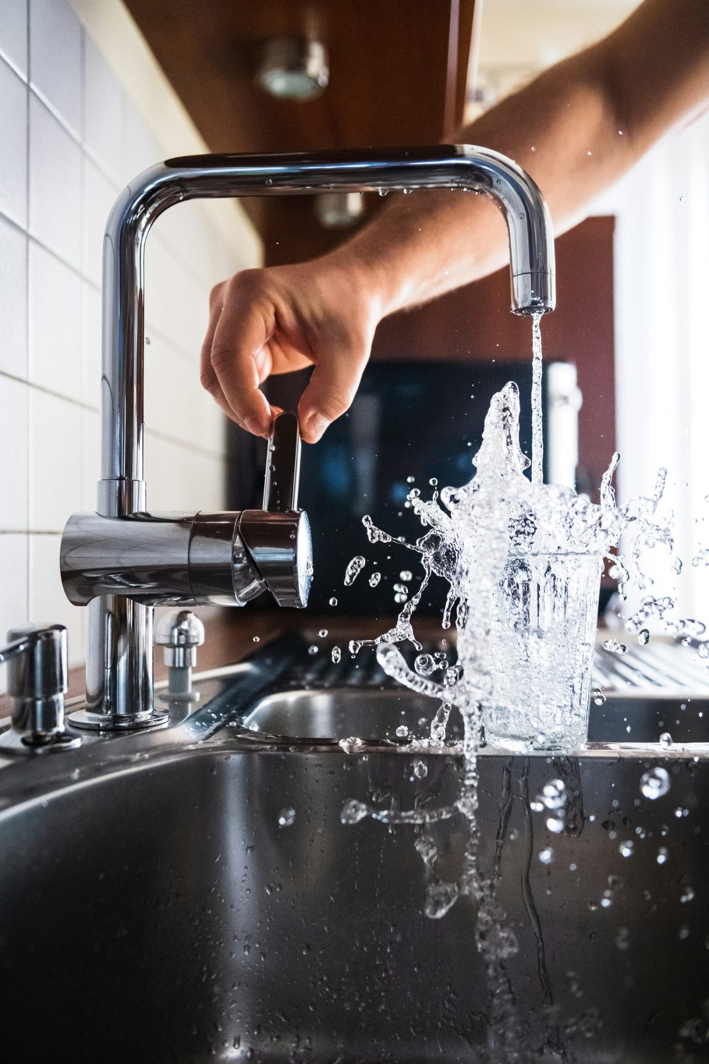Tap running into a glass with a splash of water